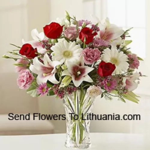 Roses rouges, œillets roses, gerberas blancs et lys blancs avec d'autres fleurs assorties dans un vase en verre